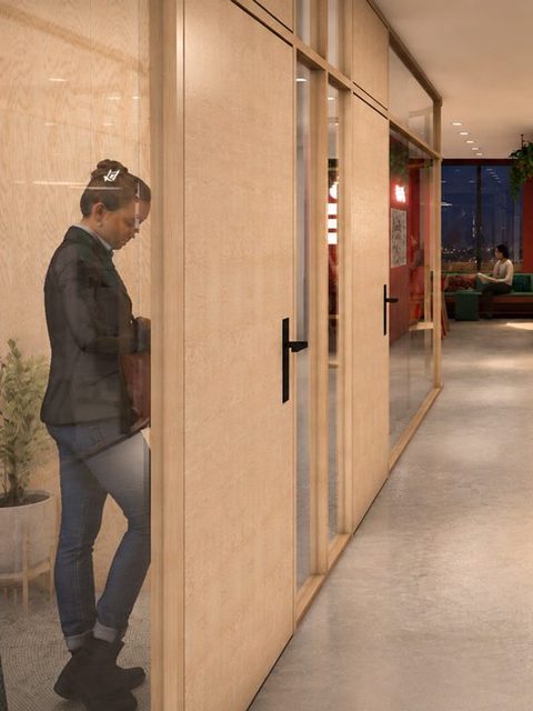 Flur mit Wänden aus hellem Holz, am Ende eine rote Säule mit dem Sparkassen-S, eine Person geht hindurch