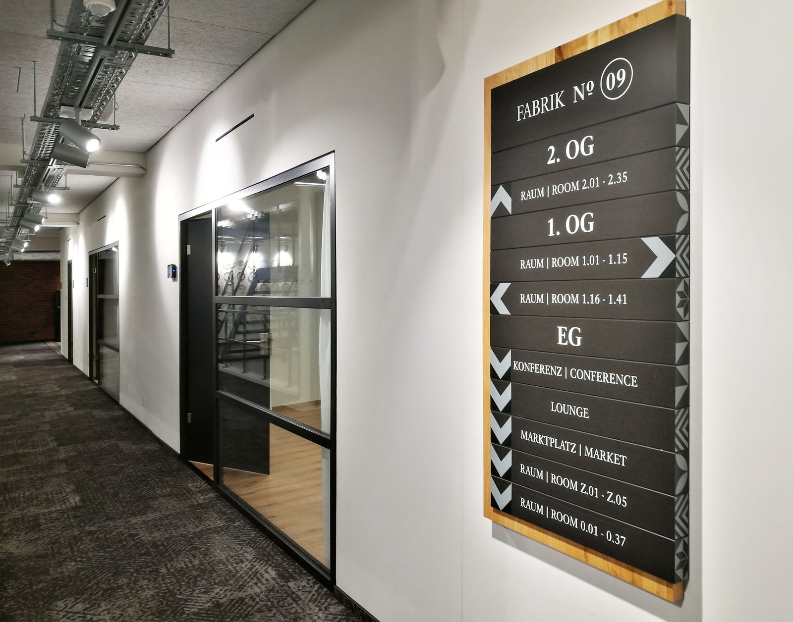 Wegeleitsystem an der Wand: Tafel mit der Aufschrift „Fabrik N° 09“ und den Stockwerksangaben