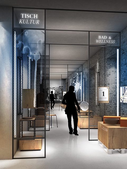 Ausstellungsgang mit Vitrinen hinter Metallgittern, Besucher als Silhouetten, rechts eine Backsteinmauer